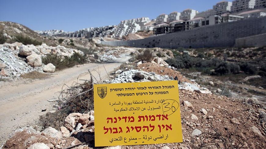 An official Israeli sign from the Civil Administration in Charge of the Government Property, placed in the West Bank near the Israeli Beitar Illit (R) settlement, states that the area is state land and trespassing is not allowed, near the Palestinian village of Wadi Fukin, on September 4, 2014. Israel over the weekend said it would expropriate 400 hectares (988 acres) of Palestinian land around Bethlehem, and allowed 45 days for any appeal. AFP PHOTO / AHMAD GHARABLI (Photo credit should read AHMAD G