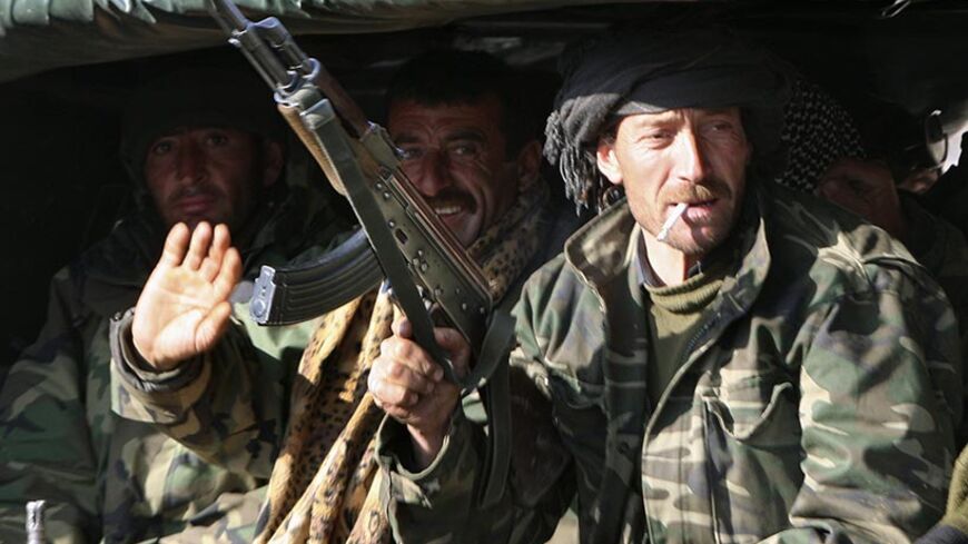 Pro-government village guards wave from their truck as they pass through the south-eastern Turkish border town of Cukurca, upon their arrival from northern Iraq, February 29, 2008. Turkey's military General Staff said on Friday that its troops had returned to bases in Turkey after a major ground offensive against Kurdish PKK rebels in northern Iraq.  REUTERS/Fatih Saribas  (TURKEY) - RTR1XQ53