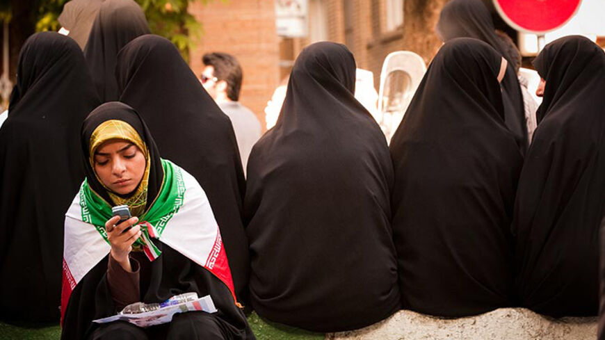 EDITORS' NOTE: Reuters and other foreign media are subject to Iranian restrictions on leaving the office to report, film or take pictures in Tehran.

A woman wearing an Iranian flag uses a mobile phone on the streets of Tehran June 16, 2009. Picture taken June 16, 2009. REUTERS via Your View  (IRAN ELECTIONS POLITICS CONFLICT) - RTR24S98