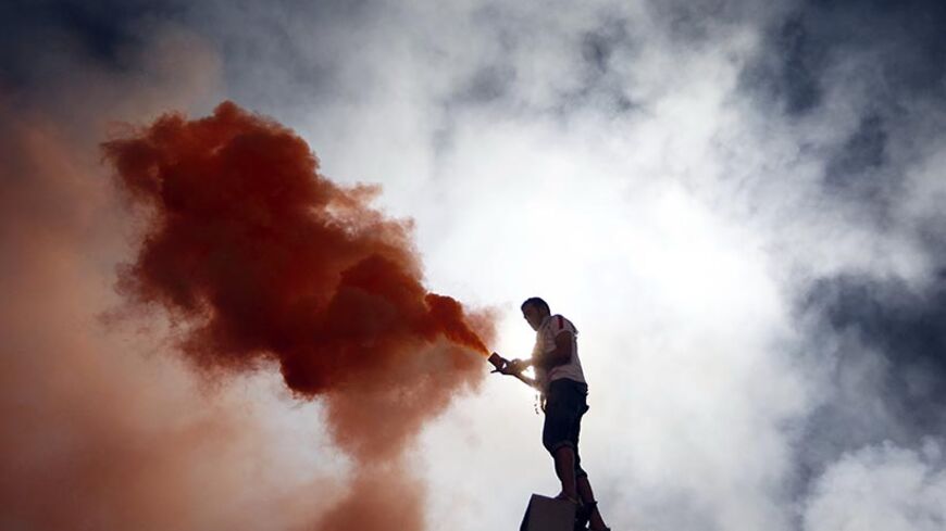 A fan of Egypt's Zamalek lights a flare during their African Champions League (CAF) soccer match against Tunisia's Club Africain at Cairo Stadium April 2, 2011. Hundreds of Zamalek supporters invaded the pitch during their team's African Champions League clash with Tunisia's Club Africain on Saturday, causing the game to be abandoned.REUTERS/Amr Abdallah Dalsh  (EGYPT - Tags: SPORT SOCCER CIVIL UNREST) - RTR2KQX4
