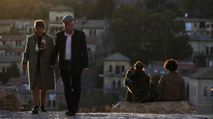 An elderly couple walk on a path leading to Jerusalem's Old City February 4, 2012. REUTERS/Amir Cohen (JERUSALEM - Tags: SOCIETY RELIGION) - RTR2XB7F