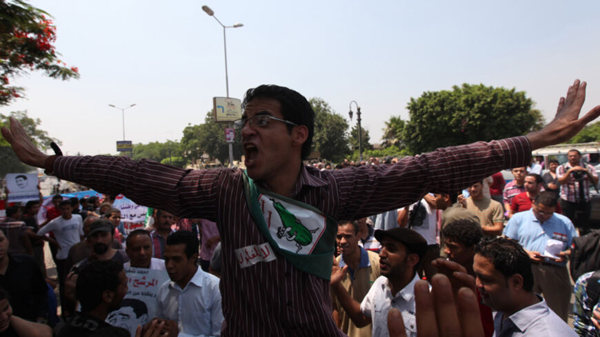 A protester shouts slogans during a demonstration against presidential candidate Ahmed Shafik, ousted leader Hosni Mubarak's last prime minister, outside the Supreme Constitutional Court in Cairo June 14, 2012. Shafik welcomed court rulings that let him stay in Egypt's leadership race and void a parliamentary vote won by his Islamist rivals, saying on Thursday an "era of political score settling" was over. REUTERS/Amr Abdallah Dalsh (EGYPT - Tags: POLITICS CIVIL UNREST ELECTIONS) - RTR33MGH