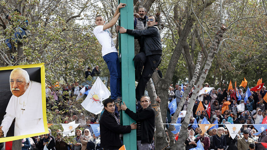 A poster depicting U.S.-based Muslim cleric Fethullah Gulen as a pope, is seen as supporters of the ruling AK Party attend an election rally in Konya, central Turkey, March 28, 2014. Erdogan pulled out of election rallies in central Turkey on Friday in order to rest his voice after weeks of campaigning around the country, his office said. Erdogan had difficulty speaking at rallies in southeast Turkey on Thursday ahead of Sunday's local elections. Turkey will hold municipal elections on March 30. REUTERS/Umi