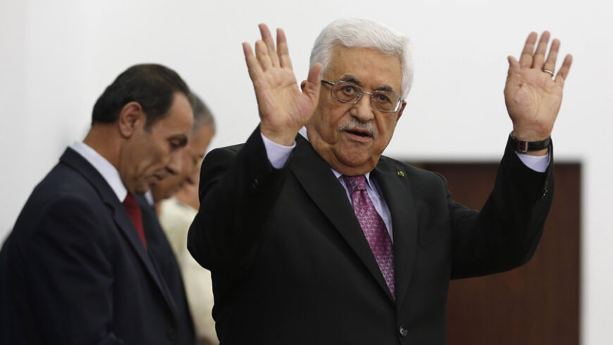 Palestinian President Mahmoud Abbas waves during a swearing-in ceremony of the unity government, in the West Bank city of Ramallah June 2, 2014. Abbas swore in a unity government on Monday after overcoming a last-minute dispute with the Hamas Islamist group.
REUTERS/Mohamad Torokman (WEST BANK - Tags: POLITICS) - RTR3RT40