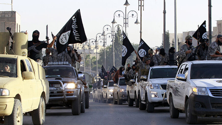 Militant Islamist fighters parade on military vehicles along the streets of northern Raqqa province June 30, 2014. Militant Islamist fighters held a parade in Syria's northern Raqqa province to celebrate their declaration of an Islamic "caliphate" after the group captured territory in neighbouring Iraq, a monitoring service said. The Islamic State, an al Qaeda offshoot previously known as Islamic State in Iraq and the Levant (ISIL), posted pictures online on Sunday of people waving black flags from cars and