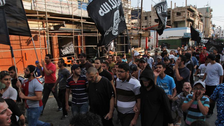 Lebanese Sunni Islamist shouts slogans and wave flags as they march during a protest in Tripoli, northern Lebanon, August 4, 2014, condemning the Lebanese army for bombarding Arsal. The Lebanese army advanced on Monday into a border town attacked by Islamists at the weekend in the most serious spillover of the three-year-old Syrian civil war into Lebanon, and the Beirut government said the deadly assault would not go unpunished. REUTERS/Omar Ibrahim (LEBANON - Tags: POLITICS CIVIL UNREST) - RTR417HT