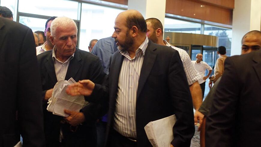 Senior Hamas official and delegation leader Moussa Abu Marzouk (R) talks with Fatah official and delegation leader Azzam Ahmed (C) as they arrive at a hotel after negotiations in Cairo August 13, 2014. The threat of renewed war in Gaza loomed on Wednesday as the clock ticked toward the end of a three-day ceasefire with no sign of a breakthrough in indirect talks in Cairo between Israel and the Palestinians. Seen at left is Maher al-Taher from the Popular Front for the Liberation of Palestine. REUTERS/Asmaa