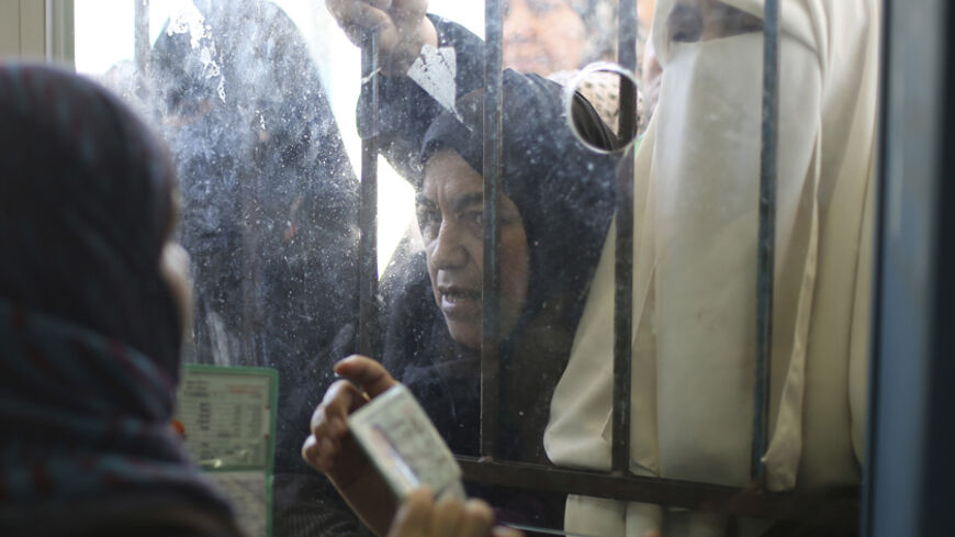 Palestinians wait to receive food supplies from a United Nations food distribution center in Khan Younis in the southern Gaza Strip August 19, 2014. REUTERS/Ibraheem Abu Mustafa (GAZA - Tags: POLITICS CIVIL UNREST CONFLICT) - RTR42YE1