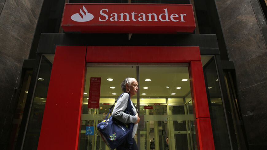 A woman walks past a Banco Santander branch in downtown
 Rio de Janeiro August 19, 2014. Picture taken August 19, 2014. REUTERS/Pilar Olivares (BRAZIL - Tags: BUSINESS) - RTR435W5