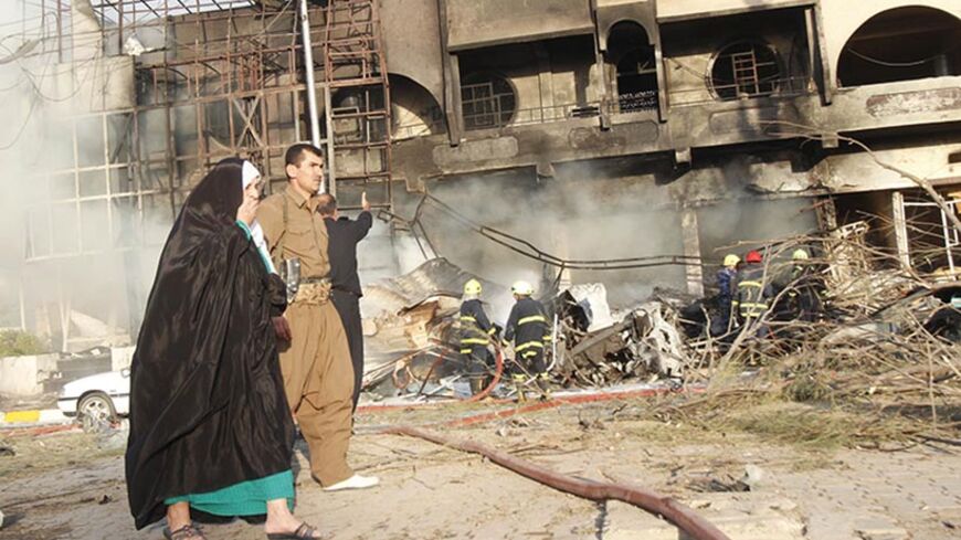 A woman reacts as she walks past the scene of a car bomb attack in Kirkuk August 23, 2014. Bombings across Iraq killed at least 35 people in attacks that appeared to be revenge for an assault on a Sunni mosque that has deepened sectarian conflict. REUTERS/Ako Rasheed (IRAQ - Tags: POLITICS CIVIL UNREST CONFLICT RELIGION TPX IMAGES OF THE DAY) - RTR43GSR