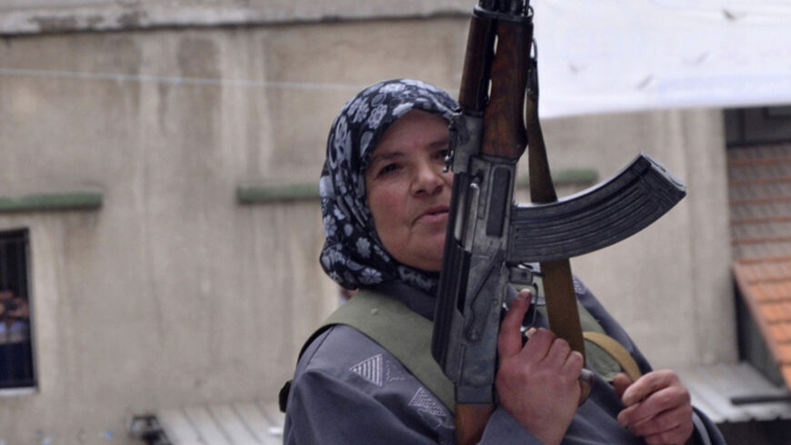 A woman carries a weapon during the funeral of Lebanese soldier Ali al-Sayyed, who was beheaded by Islamic State militants in Arsal, in his hometown of Fnideq in Akkar September 3, 2014. Islamic State militants beheaded al-Sayyed, a Lebanese soldier who was one of 19 captured by hardline Syrian Islamists when they seized the Lebanese border town for a few days last month, a video posted on social media showed on Saturday.  REUTERS/Stringer (LEBANON - Tags: POLITICS CIVIL UNREST MILITARY CONFLICT) - RTR44TMB