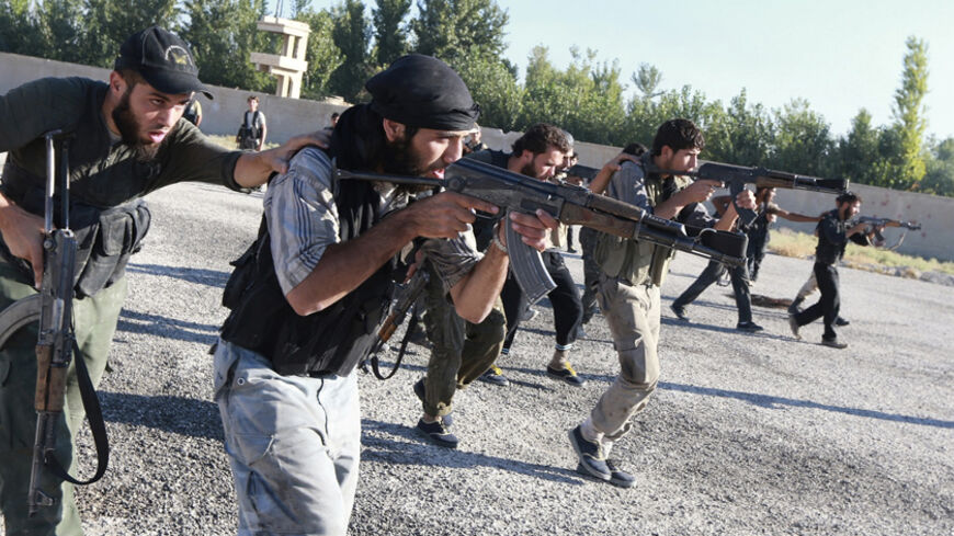 Rebel fighters demonstrate their skill with their weapons during a military display as part of a graduation ceremony at a camp in eastern al-Ghouta, near Damascus September 4, 2014. The newly graduated rebel fighters, who went through military training, will join the "Al-Habib al-Mustafa" Brigades. REUTERS/Bassam Khabieh (SYRIA - Tags: POLITICS CIVIL UNREST CONFLICT) - RTR44WPX