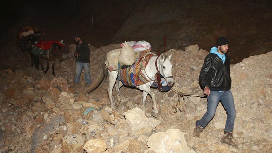 Syrians, who fled the fighting in their country, arrive with their belongings at night in the Shebaa region, southern Lebanon, November 11, 2013. Picture taken November 11, 2013. REUTERS/Karamallah Daher (LEBANON - Tags: POLITICS CIVIL UNREST CONFLICT) - RTX15A7X