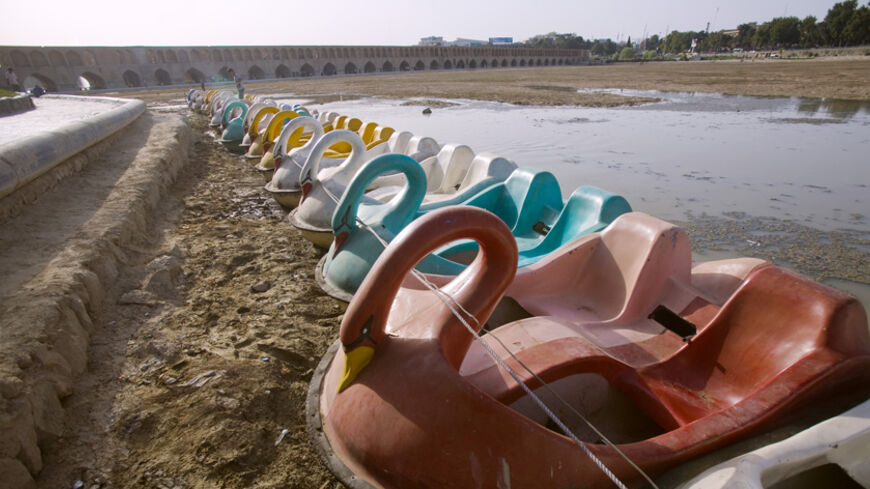 Fun boats lie on the bank of the dried-up Zayanderood River in Isfahan, 450 km (281 miles) south of Tehran, June 27, 2008. The river dried up due to low rainfall and the water being re-channelled for hydroelectricity purposes. REUTERS/Morteza Nikoubazl (IRAN) - RTX7EUD