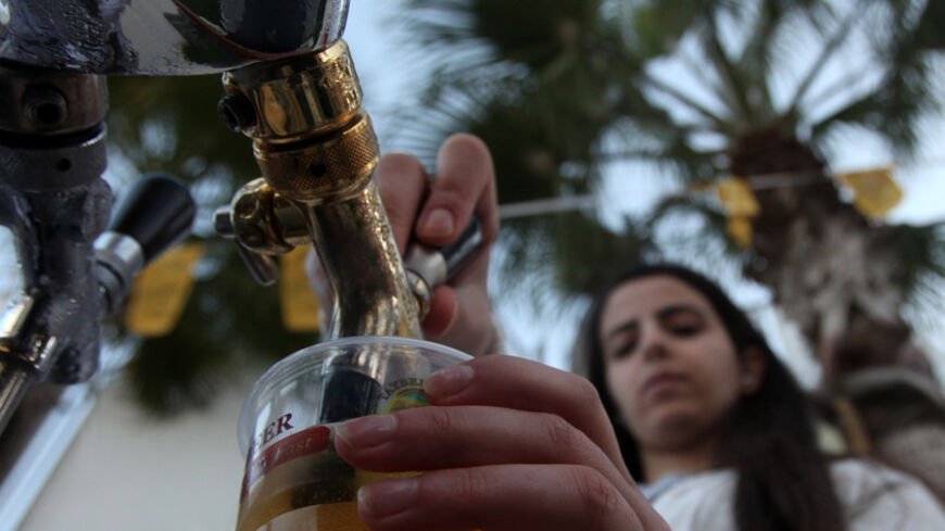 A woman serves beer during the 2013 Taybeh Oktoberfest beer festival in the West Bank Christian village of Taybeh, near Ramallah, on October 5, 2013. The annual beer festival is put on by the Taybeh brewery, the only such establishment in the predominantly Muslim Palestinian territories. AFP PHOTO/ABBAS MOMANI (Photo credit should read ABBAS MOMANI/AFP/Getty Images)