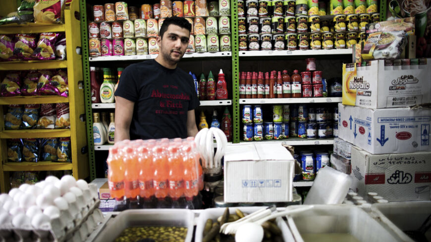 TO GO WITH AFP STORY BY ARTHUR MACMILLAN
Iranian Ali Heydari, 22, poses at his grocery in southern Tehran on April 22, 2014, claiming that prices are still increasing and his sales decreasing. Iran's President Hassan Rouhani was elected on hopes that he could revive the country's sanctions-neutered economy, but the public's goodwill towards him is showing the first signs of fading. AFP PHOTO/BEHROUZ MEHRI        (Photo credit should read BEHROUZ MEHRI/AFP/Getty Images)