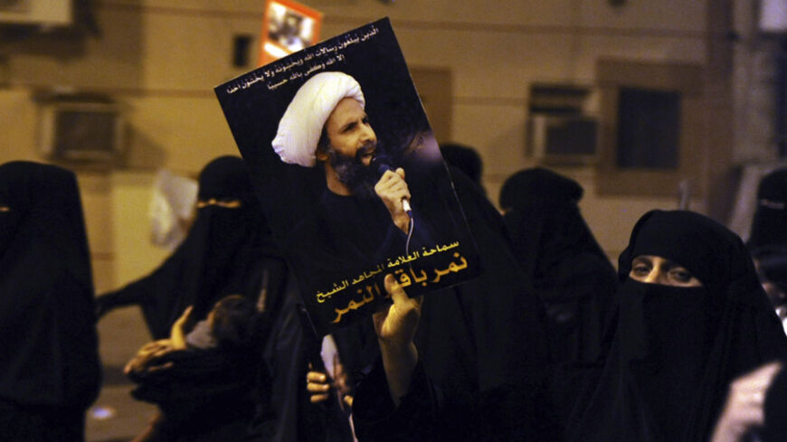 A protester holds up a picture of Sheikh Nimr al-Nimr during a rally at the coastal town of Qatif, against Sheikh Nimr's arrest July 8, 2012. Sheikh Nimr, a prominent Shi'ite Muslim cleric who was wanted by the police, was detained in Saudi Arabia's Eastern Province on Sunday over calls for more rights for the minority Muslim sect in the Sunni monarchy, his brother and an activist said. REUTERS/Stringer (SAUDI ARABIA - Tags: CIVIL UNREST RELIGION POLITICS) - RTR34QU8