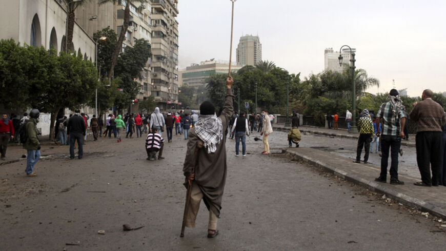 A disabled protester opposing Egyptian President Mohamed Mursi waves a broom towards police during clashes along Qasr Al Nil bridge leading to Tahrir Square in Cairo January 28, 2013. A man was shot dead on Monday in a fifth day of violence inEgypt that has killed 50 people and prompted the Islamist president to declare a state of emergency in an attempt to end a wave of unrest sweeping the Arab world's biggest nation.  REUTERS/Asmaa Waguih (EGYPT - Tags: POLITICS CIVIL UNREST) - RTR3D3EP