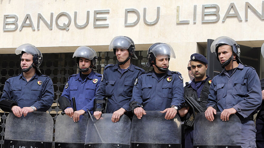 Lebanese riot police stand guard at the Lebanese Central Bank in Beirut February 25, 2013. An open-ended strike by teachers and civil servants entered its second week today for the government to approve the wage hike proposal. REUTERS/Mohamed Azakir (LEBANON - Tags: POLITICS CIVIL UNREST) - RTR3E9U4