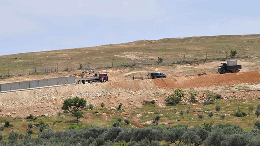 Concrete slabs are placed on the Turkish-Syrian border during the construction of a wall in Reyhanli, southern Hatay province April 28, 2014. Turkey has started building a new wall along a fragment of its southeastern border with Syria as it struggles against smuggling, illegal migration and the threat from al Qaeda fighters among Syria's rebel ranks. Picture taken April 28, 2014. REUTERS/Cihan News Agency (TURKEY - Tags: SOCIETY IMMIGRATION CIVIL UNREST POLITICS) TURKEY OUT. NO COMMERCIAL OR EDITORIAL SALE