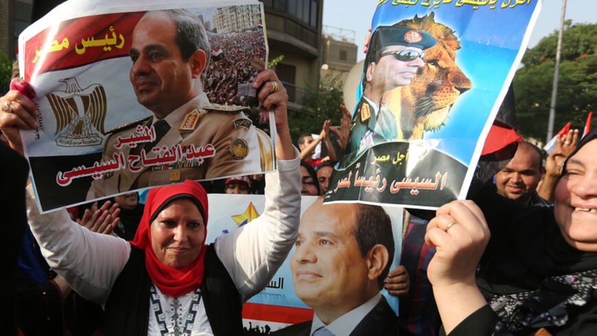 People celebrate in front of a polling station during the presidential elections in Cairo May 26, 2014. Egyptians voted on Monday in a presidential election expected to sweep former army chief Abdel Fatah al-Sisi into office, with supporters brushing aside concerns about human rights and hailing him as the strong leader the country needs. REUTERS/Mohamed Abd El Ghany (EGYPT - Tags: POLITICS ELECTIONS) - RTR3QYDW