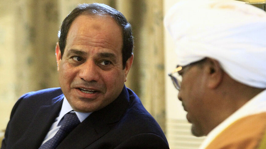 Egypt's President Abdel Fattah al-Sisi (L) talks to Sudan's President Omar al-Bashir at Khartoum International Airport in Khartoum June 27, 2014. REUTERS/Mohamed Nureldin Abdallah (SUDAN - Tags: POLITICS) - RTR3W4LF