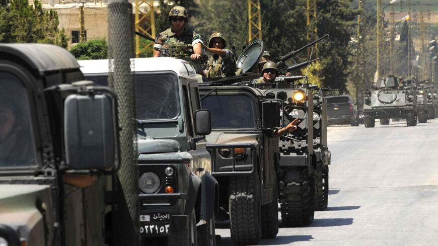 Lebanese army soldiers on military vehicles and armoured carriers advance towards the Sunni Muslim border town of Arsal, in eastern Bekaa Valley as part of reinforcements August 4, 2014. The Lebanese army advanced on Monday into a border town attacked by Islamists at the weekend in the most serious spillover of the three-year-old Syrian civil war into Lebanon. A dozen armoured personnel carriers were seen advancing towards the town, together with a similar number of other military vehicles including trucks 