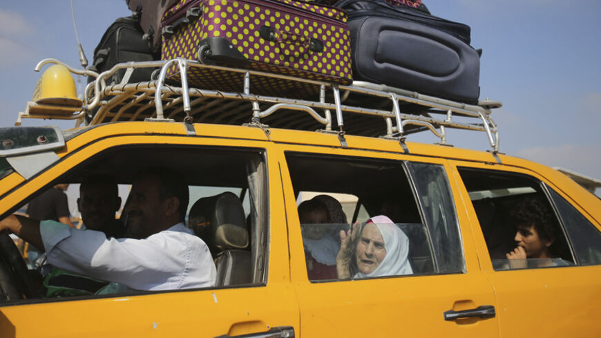 Palestinians, hoping to cross into Egypt, ride in a car as they wait at the Rafah crossing in the southern Gaza Strip August 25, 2014. Under Egyptian President Abdel Fattah al-Sisi, Cairo has secured closures on the Gaza border, increasing economic pressure on Hamas from a long-running Israeli blockade. Israel's Prime Minister Benjamin Netanyahu warned Palestinian civilians on Sunday to leave immediately any site where militants are operating, one day after Israel flattened a 13-storey apartment block in Ga