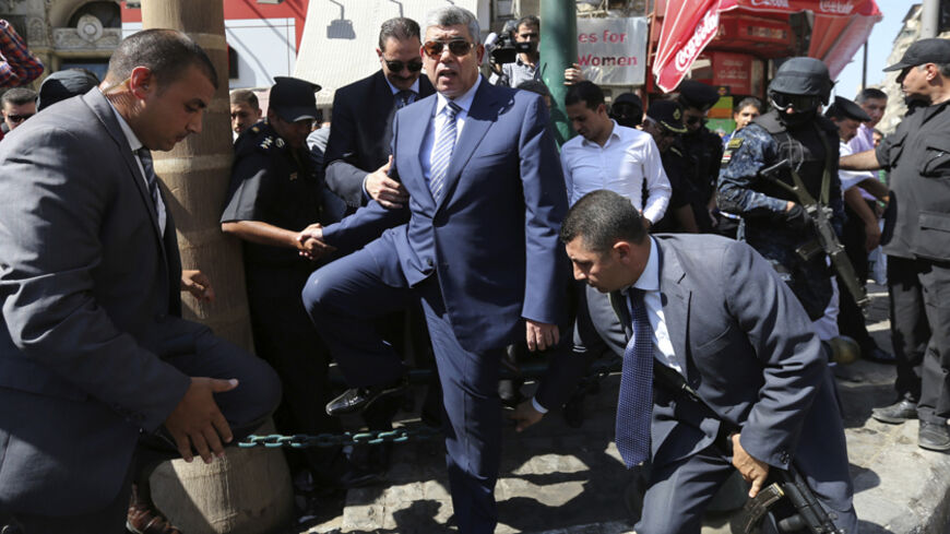 Egypt's Interior Minister Mohamed Ibrahim (C), surrounded by security guards, walks along a street near Talaat Harb square, in downtown Cairo August 25, 2014. Security forces on Sunday cleared the streets near Talaat Harb Square, as the Interior Ministry launches a campaign to increase the presence of security forces in downtown Cairo, according to local media.   REUTERS/Mohamed Abd El Ghany (EGYPT - Tags: POLITICS CIVIL UNREST MILITARY) - RTR43NMP