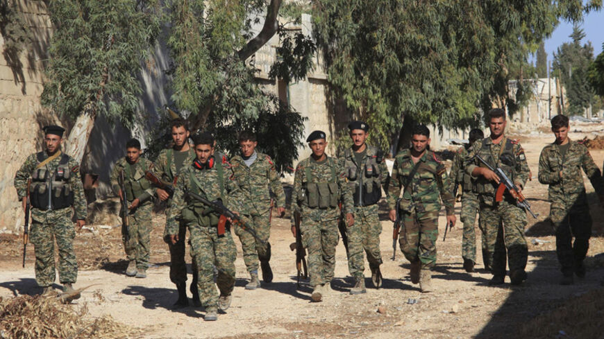 Forces loyal to Syria's President Bashar al-Assad hold their weapons as they walk in Handarat area, north of Aleppo, after saying they have regained control of the area, October 4, 2014. The Syrian army has taken control of three villages, state television said, in a campaign by Assad's forces that could encircle insurgents in the city. Although there are smaller, more indirect routes into Aleppo, taking the northern road would also allow the army to besiege areas of the city which fell to insurgents in 201