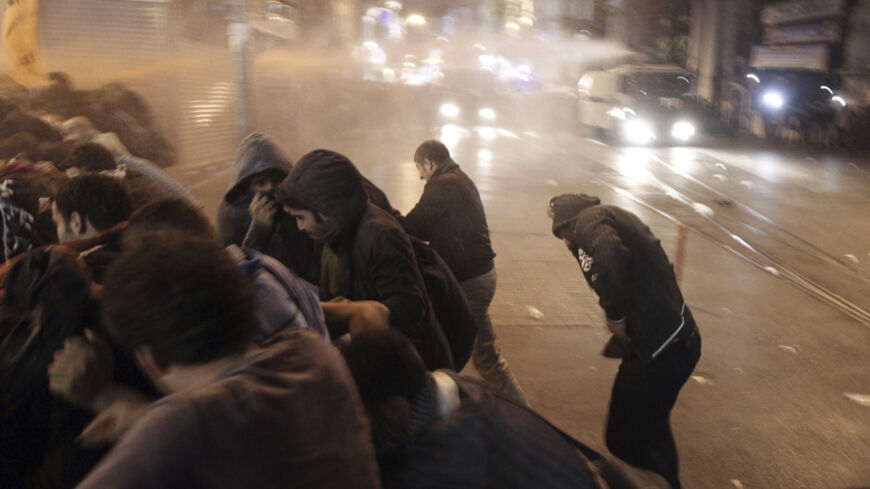 Protesters run from a water cannon used by riot police to disperse them in Istanbul, during a pro-Kurdish demonstration in solidarity with the people of the Syrian Kurdish town of Kobani, October 7, 2014. Turkey's president said Kobani was "about to fall" as Islamic State fighters pressed home a three-week assault that has cost a reported 400 lives and forced thousands to flee their homes. REUTERS/Osman Orsal (TURKEY - Tags: CIVIL UNREST POLITICS TPX IMAGES OF THE DAY) - RTR49AWY