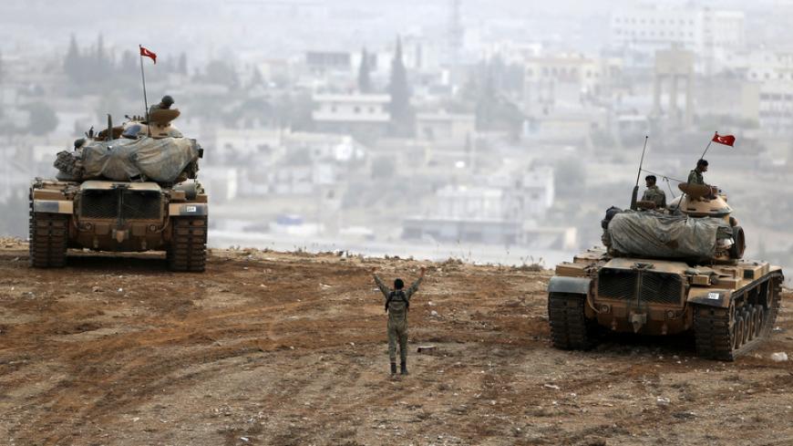 Turkish army tanks take position on top of a hill near Mursitpinar border crossing in the southeastern Turkish town of Suruc in Sanliurfa province October 11, 2014. A senior Kurdish militant has threatened Turkey with a new Kurdish revolt if it sticks with its current policy of non-intervention in the battle for the Syrian town of Kobani. Kurdish forces allied to the Kurdistan Workers' Party (PKK), the People's Defence Units (YPG), are fighting against Islamic State insurgents attacking Kobani close to the 