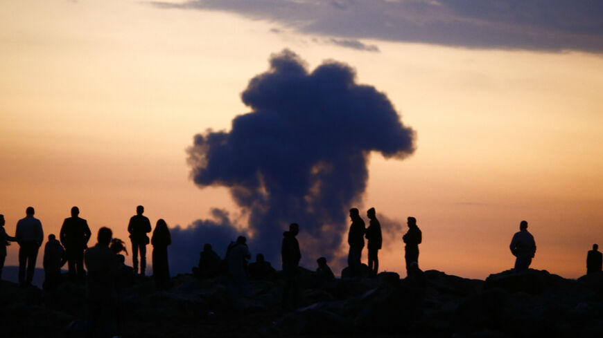 Turkish Kurds watch the smoke rises from Syrian town of Kobani near the Mursitpinar border crossing, on the Turkish-Syrian border in the southeastern town of Suruc in Sanliurfa province, October 18, 2014. A U.S.-led military coalition has been bombing Islamic State fighters who hold a large swathe of territory in both Iraq and Syria, two countries involved in complex multi-sided civil wars in which nearly every country in the Middle East has a stake..    REUTERS/Kai Pfaffenbach (TURKEY  - Tags: MILITARY POL