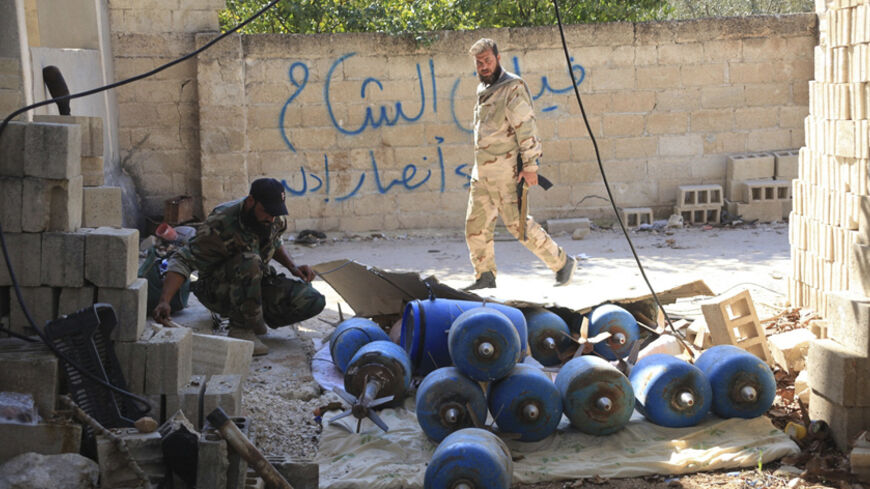 Forces loyal to Syria's President Bashar al-Assad inspect weapons, which they said were used by rebel fighters, in the town of Morek after they regained control of the area October 24, 2014. The Syrian army has regained control of a town on the highway linking Hama and Aleppo cities in western Syria after months of battles with insurgents, state television and a monitoring group said on Friday.
 The recapture of Morek, 30km (19 miles) north of Hama, is part of the military's campaign to shore up territory i
