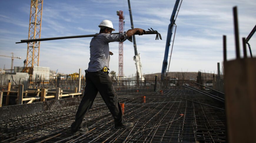A labourer works on an apartment building under construction in a Jewish settlement known to Israelis as Har Homa and to Palestinians as Jabal Abu Ghneim in an area of the West Bank that Israel captured in a 1967 war and annexed to the city of Jerusalem, October 28, 2014. Israeli Prime Minister Benjamin Netanyahu will expedite planning for some 1,000 settler homes in East Jerusalem, a government official said on Monday, in a bid to placate a restive coalition ally without further aggravating a dispute with