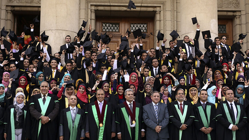 Gaber Gad Nassar (front row, C), president of Cairo University, poses with graduating Engineering students after an interview with Reuters in Cairo October 15, 2014. The government has tightened security at the university as it seeks to avert another year of unrest on university campuses, among the last bastions of protest and dissent in Egypt. Nassar denied the security measures were intended to restrict academic freedoms. Picture taken October 15.     REUTERS/Mohamed Abd El Ghany (EGYPT - Tags: EDUCATION 
