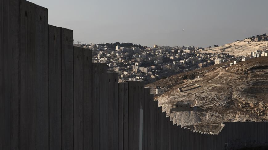 The golden Dome of the Rock (C) in Jerusalem's old city is seen in the distance beyond a section of the controversial Israeli barrier in the West Bank city of Abu Dis, October 29 , 2014. The Dome of the Rock is situated within the Al-Aqsa compound, known to Muslims as Noble Sanctuary and to Jews as Temple Mount. On the 25th anniversary of the fall of the Berlin Wall, there are still barriers separating communities around the world, from the barbed wire fence dividing the two Koreas, the fence around the Spa