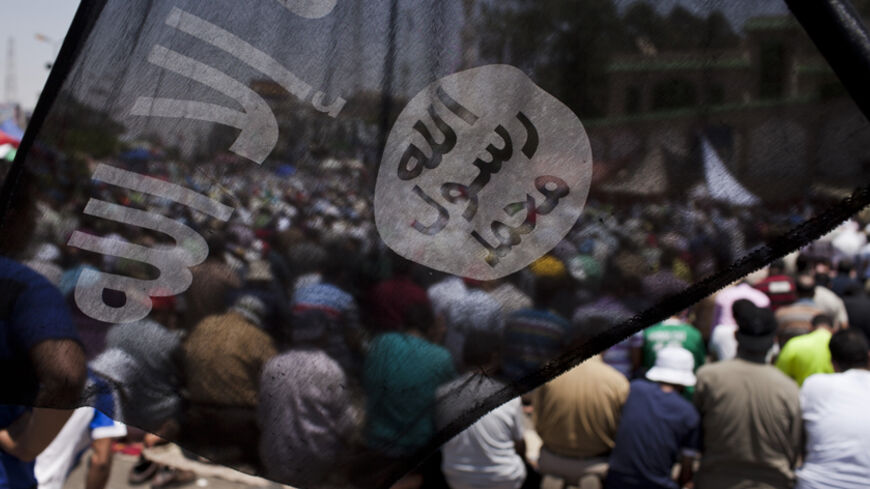 CAIRO, EGYPT - JULY 04:  A black flag associated with salafist islamist movement flies in from of supportors of of former Egyptian President Mohammed Morsi perform midday prayers, the morning after Morsi, the country's first democratically elected president, was ousted from power on July 4, 2013 in Cairo, Egypt. Adly Mansour, chief justice of the Supreme Constitutional Court, was sworn in as the interim head of state in ceremony in Cairo in the morning of July 4, the day after Morsi was placed under house a