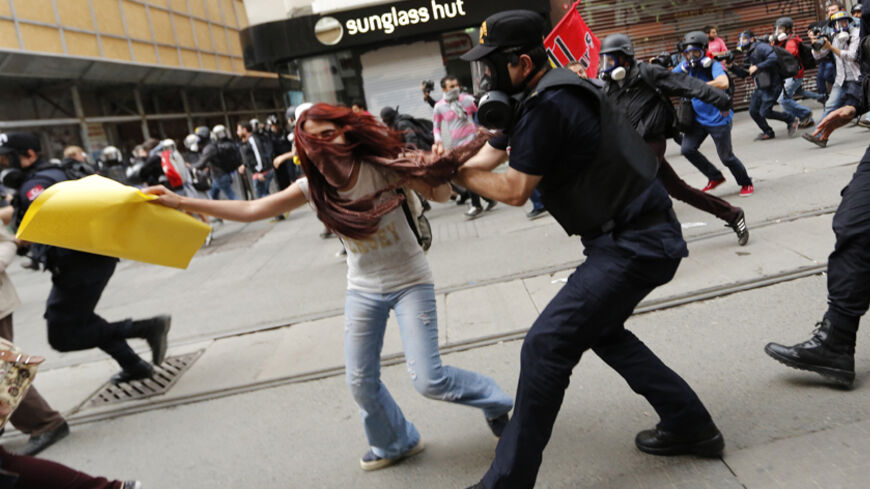 Riot police chase protesters in central Istanbul May 31, 2014. Turkish police on Saturday used teargas in central Istanbul to disperse protesters seeking to mark the one-year anniversary of the start of the biggest anti-government demonstrations in decades. Several hundred people gathered on streets leading to Taksim Square, shouting for the government's resignation, when police fired teargas at the crowd, which quickly scattered. REUTERS/Murad Sezer (TURKEY - Tags: POLITICS CIVIL UNREST ANNIVERSARY) - RTR3