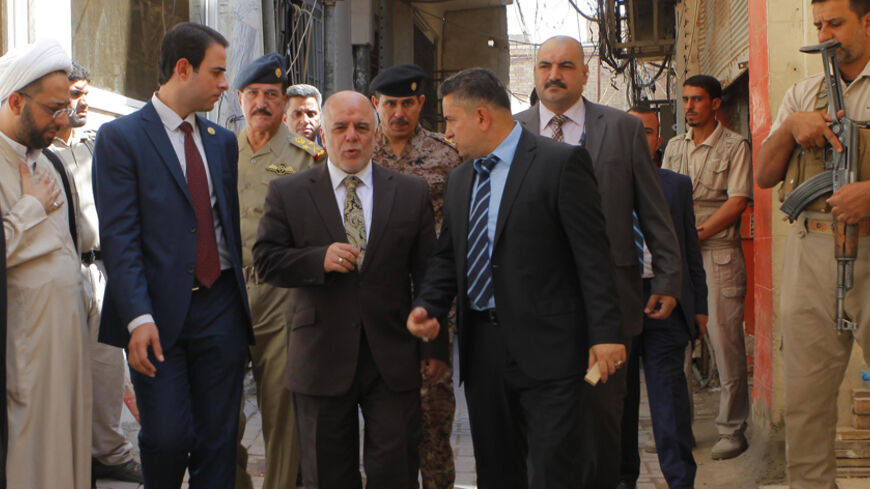 Iraqi Prime Minister Haider al-Abadi (C) walks after a meeting with the top Shiite cleric, Grand Ayatollah Ali al-Sistani, in the Shiite holy city of Najaf, south of Baghdad, October 20, 2014.  REUTERS/Alaa Al-Marjani (IRAQ - Tags: POLITICS RELIGION) - RTR4AVK4