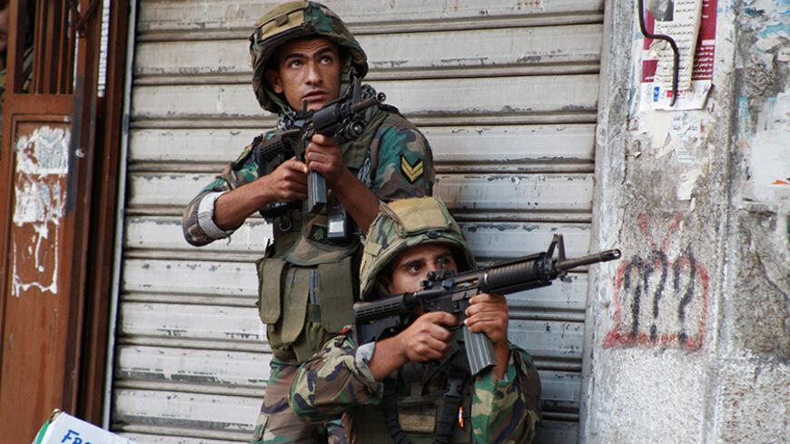 Lebanese army soldiers carry their weapons during clashes with Islamist militants in Tripoli October 25, 2014. Clashes erupted between the Lebanese army and Islamist militants on Saturday following explosions and gunfire in the streets of the northern city of Tripoli. At least two militants were killed and six soldiers - including an officer - were wounded in previous clashes between the army and Islamic gunmen in Tripoli on Friday. It was not immediately clear which group the militants represented. REUTERS