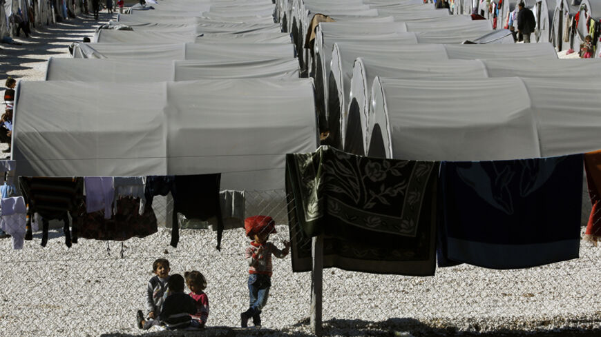 Kurdish refugees from the Syrian town of Kobani are seen inside a fenced refugee camp as they watch other children play  in the border town of Suruc, Sanliurfa province November 5, 2014.  REUTERS/Yannis Behrakis (TURKEY - Tags: MILITARY CONFLICT POLITICS) - RTR4CX33