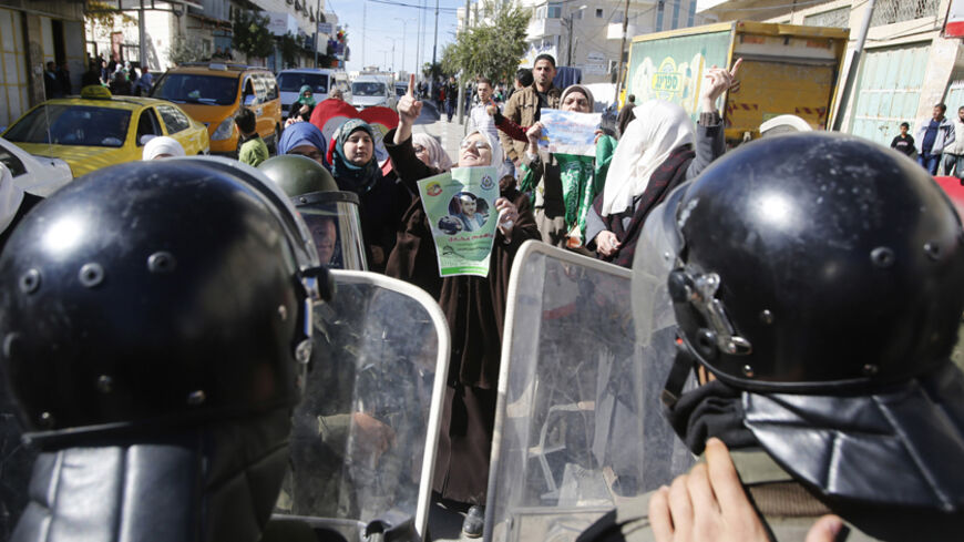Members of Palestinian security forces take position as Palestinian women take part in an anti-Israel protest against what organizers say are recent visits by Jewish activists to al-Aqsa mosque, in the West Bank city of Hebron November 7, 2014. In recent months, a campaign for the prayer ban on Jewish worshippers at the site, known to Muslims as the Noble Sanctuary and to Jews as Temple Mount, to be overturned, led by settler activists, has gathered momentum, raising alarm among Palestinians and Muslims fur