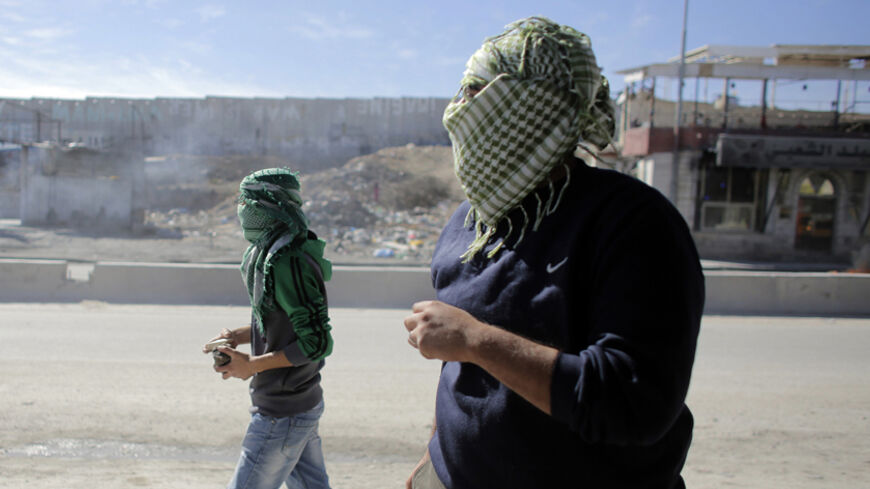 Palestinian protesters take up position during clashes with Israeli troops following a protest against what organizers say are recent visits by Jewish activists to al-Aqsa mosque, at Qalandia checkpoint near the West Bank city of Ramallah November 7, 2014. In recent months, a campaign for the prayer ban on Jewish worshippers at the site, known to Muslims as the Noble Sanctuary and to Jews as Temple Mount, to be overturned, led by settler activists, has gathered momentum, raising alarm among Palestinians and