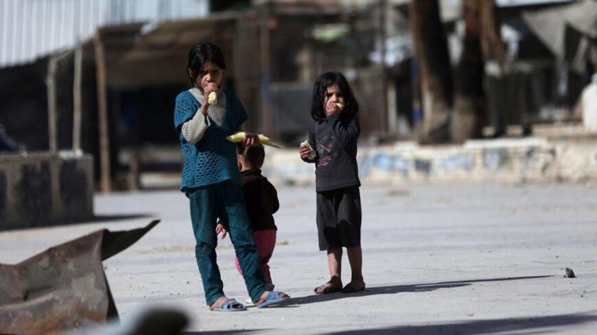 Children eat corn on the cob on a street in Douma, eastern al-Ghouta, near Damascus November 7, 2014. REUTERS/Bassam Khabieh (SYRIA - Tags: POLITICS CIVIL UNREST CONFLICT SOCIETY) - RTR4DA0I
