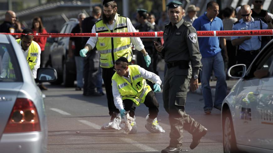 Members of the Israeli Zaka emergency response team work at the scene of a stabbing in Tel Aviv November 10, 2014. A Palestinian stabbed and critically an Israeli soldier near a Tel Aviv train station on Monday, police said, as anti-Israel violence that has raised fears of a new Palestinian uprising in the making reached the country's business capital. REUTERS/Finbarr O'Reilly (ISRAEL - Tags: POLITICS CIVIL UNREST MILITARY CRIME LAW TPX IMAGES OF THE DAY) - RTR4DJZA