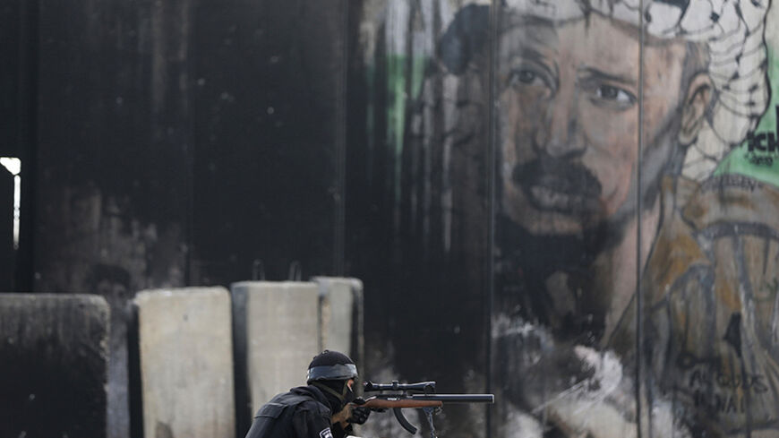 An Israeli border policeman takes position during clashes with Palestinian protesters following an anti-Israel demonstration in solidarity with al-Aqsa mosque, at Qalandia checkpoint near the West Bank city of Ramallah November 21, 2014. REUTERS/Ammar Awad (WEST BANK - Tags: POLITICS CIVIL UNREST CRIME LAW) - RTR4F1NY