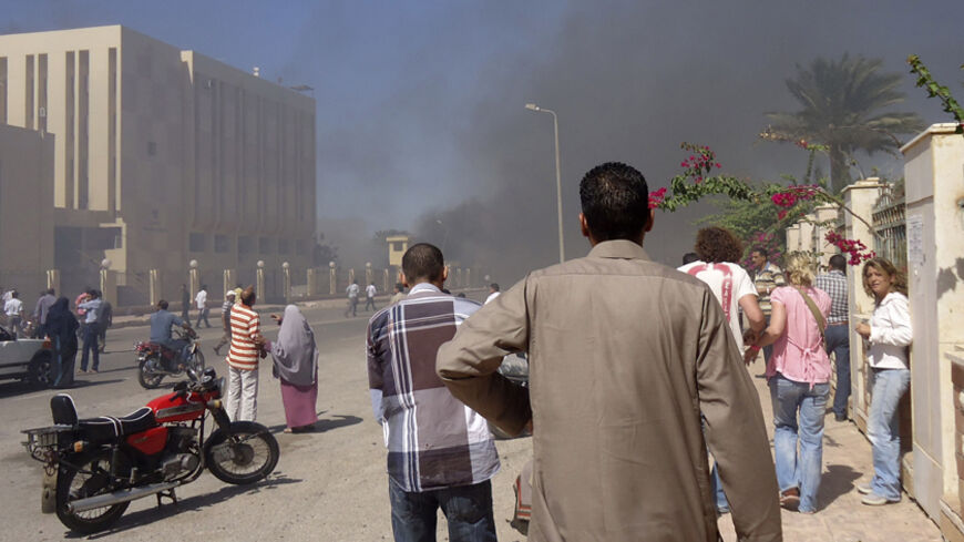 Residents and tourists watch as smoke raises near a state security building after a blast in South Sinai October 7, 2013. Medical sources said three were killed and 48 injured in the blast near the state security building in South Sinai. A witness said it was caused by a car bomb.  REUTERS/Stringer (EGYPT - Tags: POLITICS CIVIL UNREST) - RTX142T0