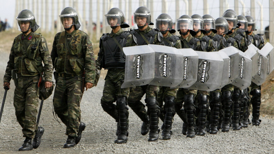 Turkish gendarme soldiers prepare to change shifts with their colleagues standing in front of protesters waiting outside Silivri prison, some 70 km (43.5 miles) west of Istanbul, during the trial of a shadowy-right wing group in the heavily-guarded prison, October 23, 2008. The trial of Ergenekon, a shadowy right-wing group, resumed in Turkey on Thursday on charges of trying to topple Prime Minister Tayyip Erdogan's government.  REUTERS/Osman Orsal (TURKEY) - RTX9U0U