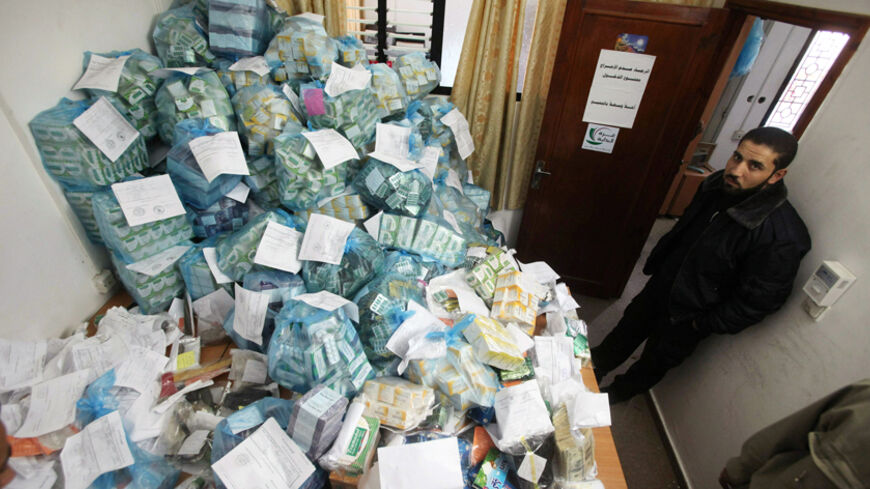A member of Hamas security forces stands next to plastic bags filed with confiscated drugs at a storage room in the prosecutor's headquarters in Gaza City December 2, 2009. Alarmed by mounting drug abuse and addiction among the cooped-up Palestinians of Gaza, Islamist rulers of the enclave plan to introduce the death penalty for gangs getting rich off smuggled narcotics. Picture taken December 2, 2009. REUTERS/Mohammed Salem (GAZA POLITICS SOCIETY CRIME LAW) - RTXREJY